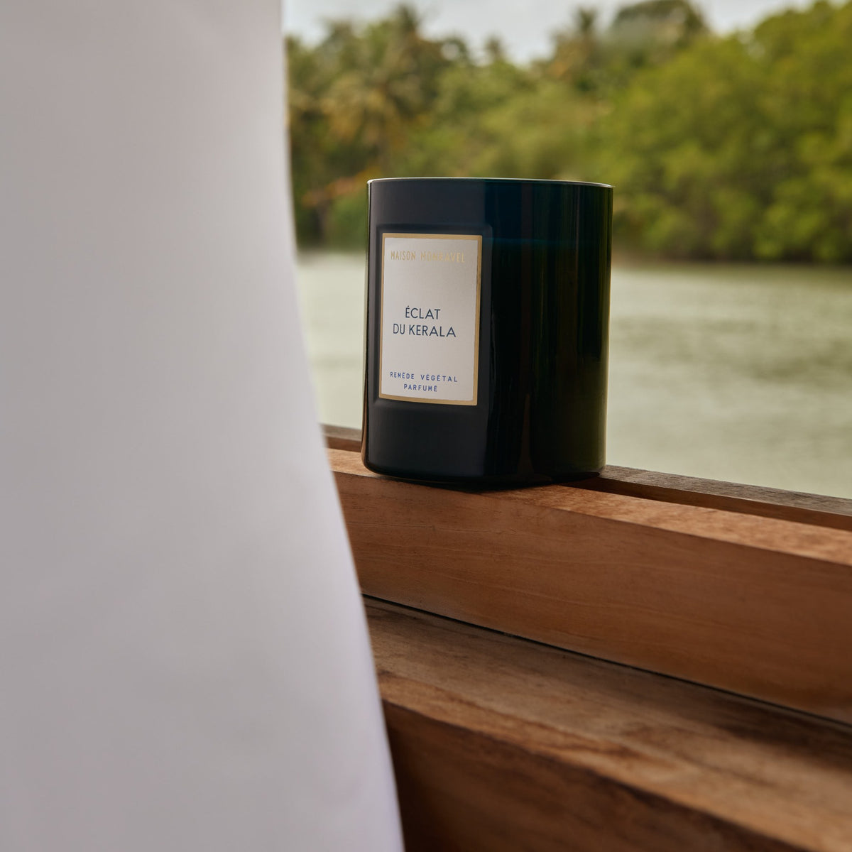 Bougie Éclat du Kerala sur le rebord d’une fenêtre ouverte sur la rivière