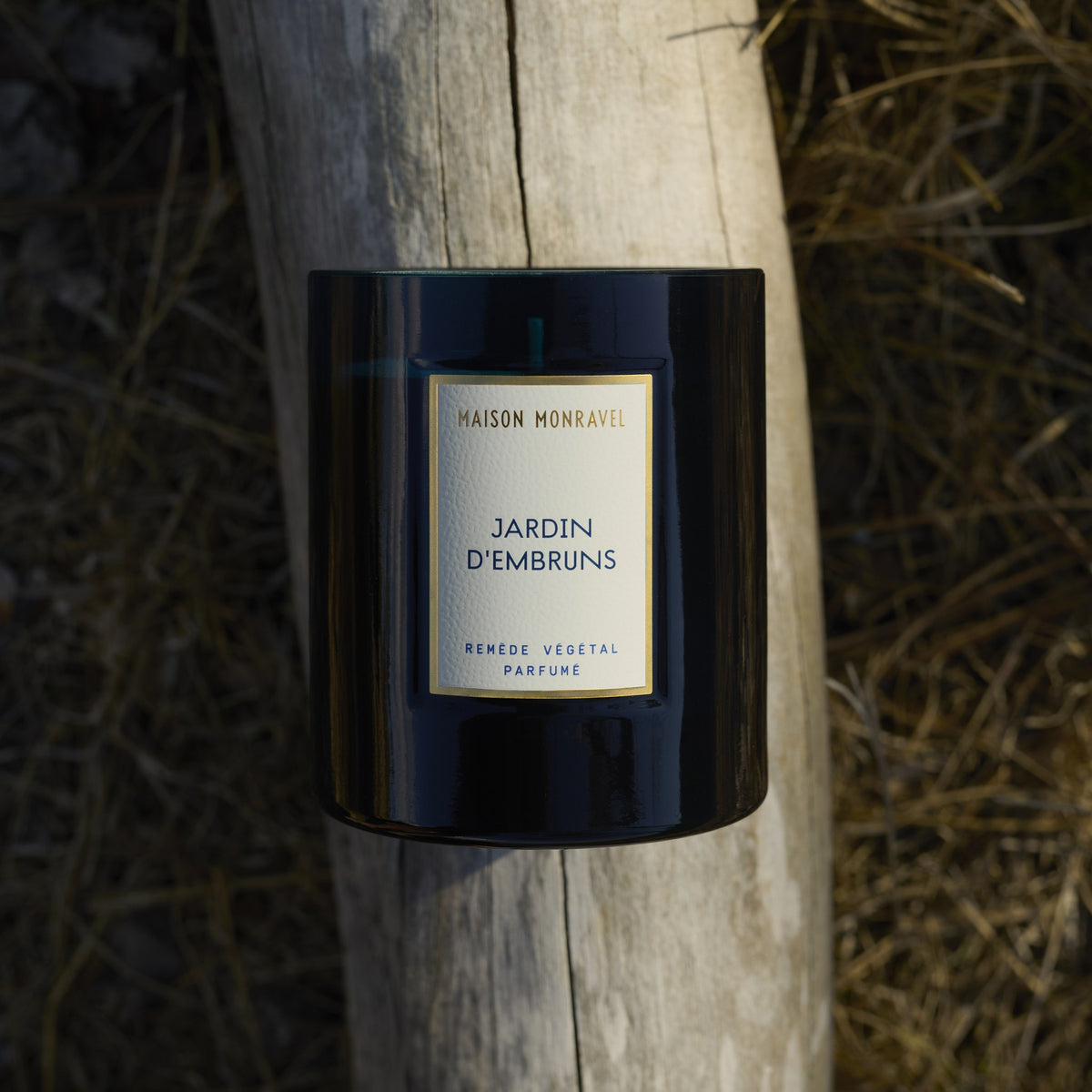 Bougie Jardin d’Embruns posée sur un bois flotté