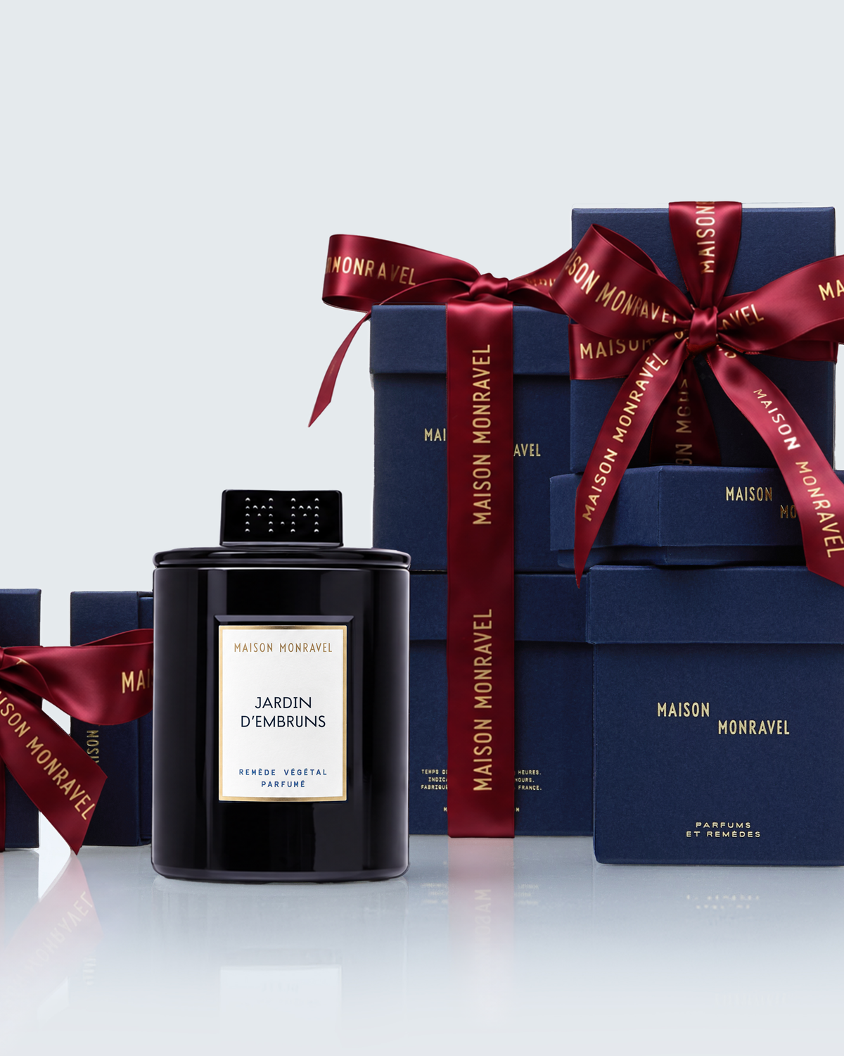 Bougie avec son capuchon en verre monogrammé et écrins cadeaux bleu indigo Maison Monravel, ruban rouge Garance